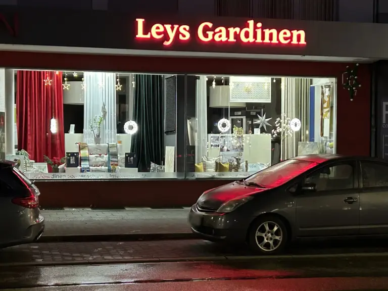 Ladenlokal von Leys Gardinen in Gelsenkirchen bei Nacht mit Ausstellung von Dekostoffen, Gardinen und Plissees